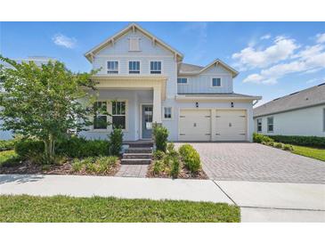 Charming two-story home with a brick driveway, manicured landscaping, and attached two-car garage at 13163 Mcmillan Dr, Orlando, FL 32827