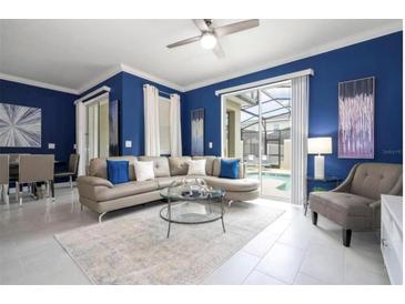 Bright living room with stylish furniture, modern decor, and sliding glass doors to the pool at 2709 Scrapbook St, Kissimmee, FL 34746