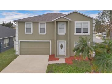 Two-story home featuring an attached garage, a well-kept lawn, and a freshly painted exterior at 1103 Epson Oaks Way, Orlando, FL 32837