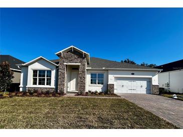 Single-story home with stone accents and a two-car garage at 329 Lady Palm St, Apopka, FL 32703