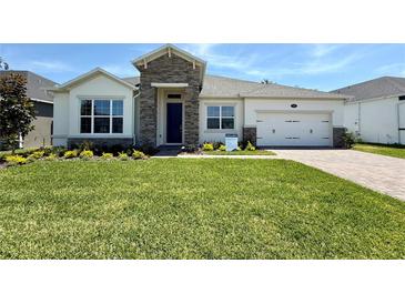 Charming single-story home featuring a well-manicured lawn and beautiful stone accents at 329 Lady Palm St, Apopka, FL 32703