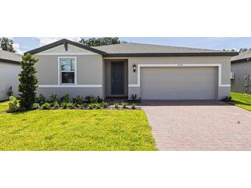 One story home with gray exterior, two car garage, and landscaped lawn at 5174 Minneola Ln, Saint Cloud, FL 34772