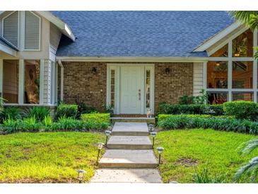 Charming home featuring a brick facade, front yard landscaping, and a welcoming front door at 530 Estates Pl, Longwood, FL 32779