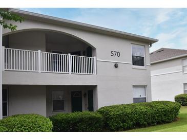 Two-story building exterior with balcony, landscaping, and building number 570 at 570 Cranes Way # 248, Altamonte Springs, FL 32701