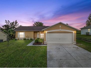 Charming one-story house with a landscaped lawn and attached garage at 12013 Woodglen Cir, Clermont, FL 34711