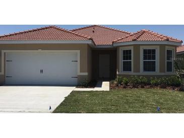 A well-kept house features a two-car garage, a terracotta roof, and a bay window, all set in a green landscaped yard at 3047 Sangria St, Kissimmee, FL 34744