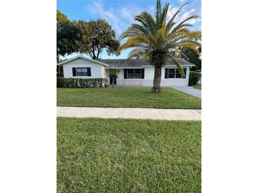 White single story house with palm trees, freshly paved driveway and manicured lawn at 858 Darwin Dr, Altamonte Springs, FL 32701