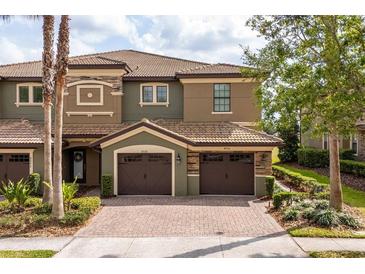 Beautiful multi-story townhome with a brick driveway and two car garage at 8930 Azalea Sands Ln, Davenport, FL 33896