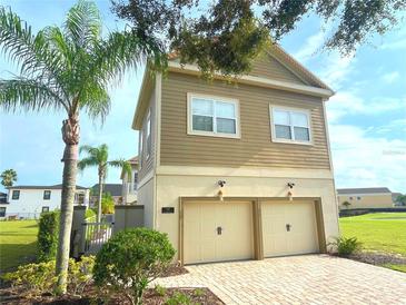 Inviting exterior with a two-car garage and manicured landscaping at 7465 Excitement Dr, Reunion, FL 34747
