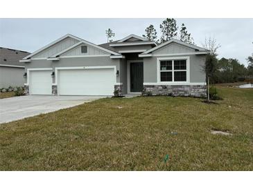 Two-car garage and neutral colored exterior at 300 Barebow Ln, Ormond Beach, FL 32174