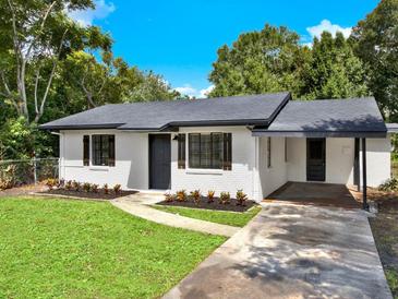 Charming brick home featuring a well-manicured lawn and a covered carport at 2512 Golfview St, Lakeland, FL 33801