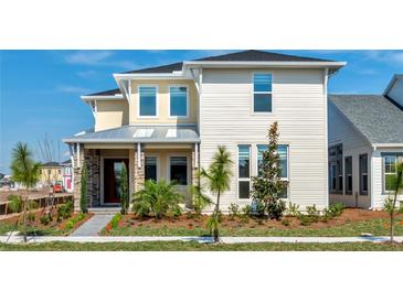 Inviting two-story home featuring a stone columned porch, manicured lawn, and a mix of modern design elements at 10257 Medawar St, Orlando, FL 32827