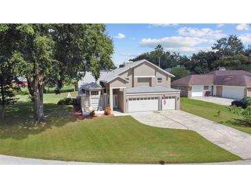 Charming two-story home with a three car garage, well-maintained lawn, and mature landscaping at 11209 Crescent Bay Blvd, Clermont, FL 34711