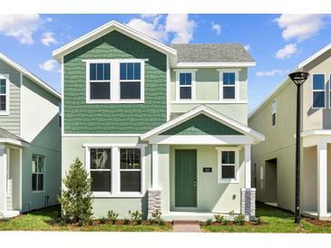 Charming two-story home with green accents, a welcoming front porch, and lush landscaping at 524 Orient Ave, Debary, FL 32713