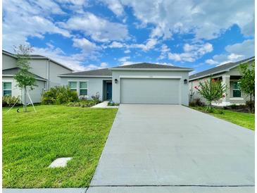 Charming single-story home with a well-manicured lawn and a two-car garage at 1393 Asher Mason Ave, Kissimmee, FL 34744