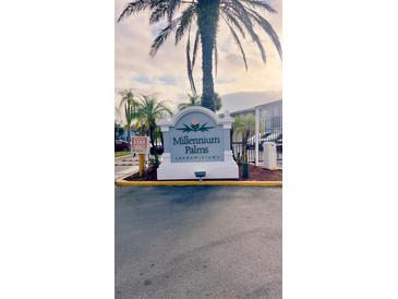 Millennium Palms Condominiums community entrance sign with lush palm trees under a cloudy sky at 4743 S Texas Ave # 4743B, Orlando, FL 32839