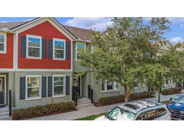 Charming townhome featuring a colorful exterior with black shutters, inviting curb appeal, and manicured landscaping at 1349 Mill Stream Ln, Winter Springs, FL 32708