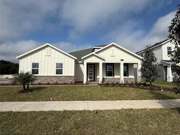 Charming single-story home showcasing a manicured lawn and stone accents at 2564 Hawks Overlook Pl, Oviedo, FL 32765