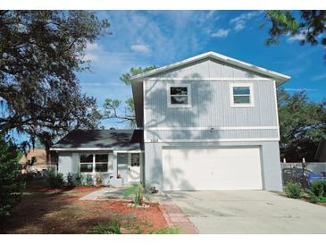 Two-story house featuring a white garage door, and trimmed front lawn with minimal foliage and a partially shaded yard at 3505 Pine Ridge Ct, Orlando, FL 32808