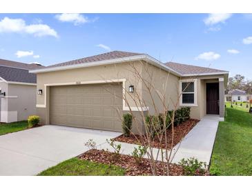 Charming single-story home with a well-manicured lawn and a two-car garage at 8626 Caribbean Pine Way, Lakeland, FL 33809