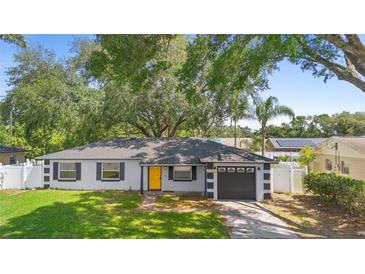 Charming single-story home featuring a bright yellow front door and an attached one-car garage at 3703 Pembrook Dr, Orlando, FL 32810