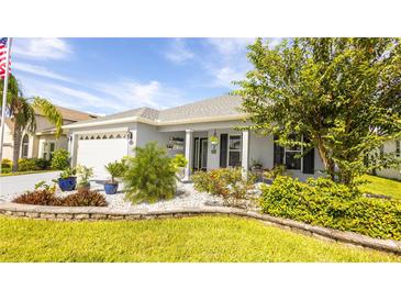 Charming single-story home with a well-manicured lawn and rock garden at 4245 Arlington Ridge Blvd, Leesburg, FL 34748
