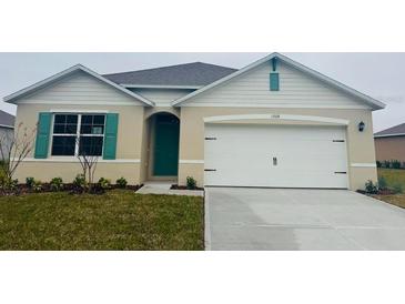 One-story house with white garage door and teal accents at 1208 Big Bass Dr, Ormond Beach, FL 32174