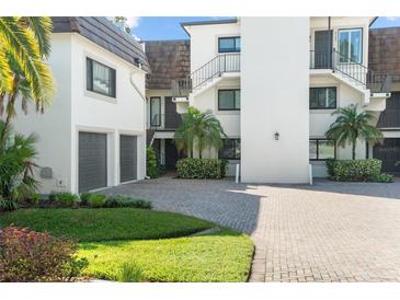 Elegant condo featuring manicured landscaping, brick driveway, and a contemporary design at 8984 Houston Pl # 103, Orlando, FL 32819