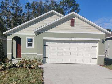 Charming single-story home with a well-maintained lawn, white garage door and craftsman architectural detailing at 304 Pelham Park Dr, Deland, FL 32720