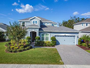 Two-story house with gray siding, landscaping, and a paved driveway at 4813 Terra Sole Place, Saint Cloud, FL 34771