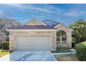 Brick home with solar panels and attached garage at 496 Mile Post Ct, Lake Mary, FL 32746