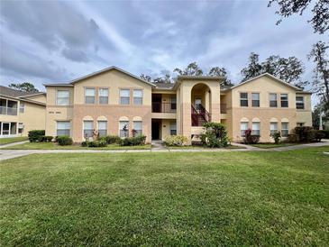 Two-story apartment building in a residential neighborhood featuring landscaped lawn and visible windows at 2878 Club Cortile Cir # A, Kissimmee, FL 34746