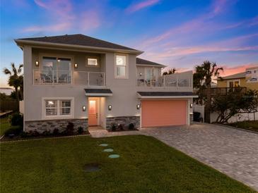 Two-story house with a pink garage door, stone accents, and a landscaped lawn at 4260 S Atlantic Ave, Port Orange, FL 32127