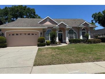 Inviting single-story home with a well-manicured lawn and a two-car garage at 1833 Queen Palm Dr, Apopka, FL 32712