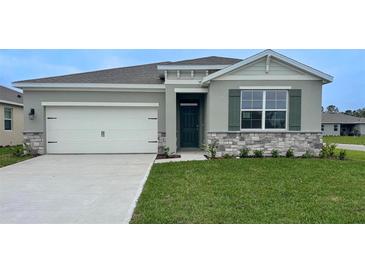 Charming single-story home with a gray exterior, stone accents, and well-manicured lawn at 314 Rover Rd, Ormond Beach, FL 32174