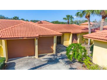 Charming single-story villa featuring a tile roof, a two-car garage, and well-maintained landscaping at 4916 Fiji Cir # 11, Orlando, FL 32808