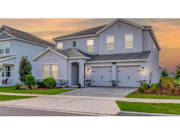 Charming two-story home with a two-car garage, neutral paint, and manicured landscaping at 11357 Satire St, Orlando, FL 32832