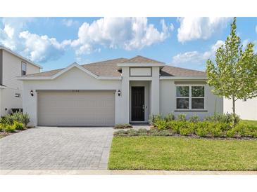 Charming single-story home featuring a well-manicured lawn, brick driveway, and neutral paint scheme at 3106 Windswept, Wildwood, FL 34785