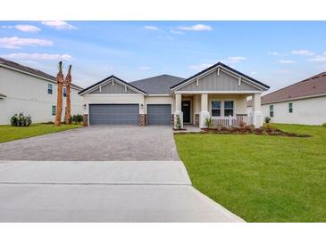 Two-story house with gray siding, a three-car garage, and a landscaped lawn at 1333 Arklow Cir, Ormond Beach, FL 32174