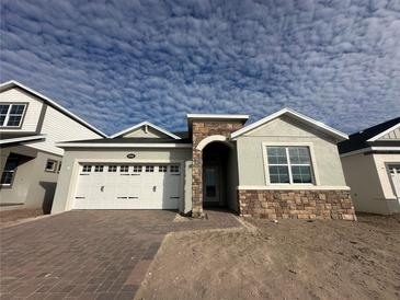 Two-story house with stone accents and a two-car garage at 5286 Teirgarten St, Saint Cloud, FL 34771