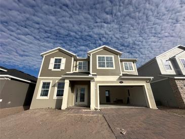 Two-story house with gray siding, white columns, and a two-car garage at 5304 Teirgarten St, Saint Cloud, FL 34771