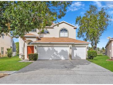 Two-story house with a two-car garage and landscaped lawn at 162 Harwood Cir, Kissimmee, FL 34744