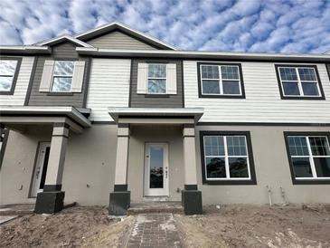 Two-story home with gray and white siding, and a covered entryway at 1376 Lumpini St, Saint Cloud, FL 34771