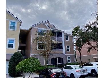 Three-story exterior view of condo with screened lanai at 3468 Soho St # 107, Orlando, FL 32835
