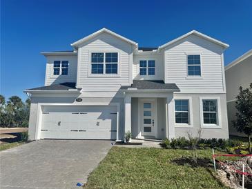 Striking two-story home featuring a clean white facade, a two-car garage, and well-manicured landscaping at 1165 Basalt Ln, Sanford, FL 32771