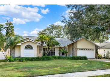 One-story house with brick facade, mature landscaping, and a two-car garage at 1007 Tony Cir, St Cloud, FL 34772