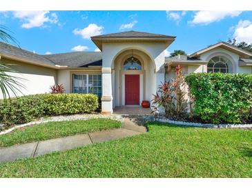 House exterior featuring a red door, landscaping, and walkway at 103 Old Sunbeam Dr, South Daytona, FL 32119