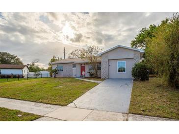 Charming one-story home with red door and landscaped lawn at 4533 San Sebastian Cir, Orlando, FL 32808