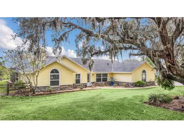 Charming yellow home with stone accents and lush lawn at 4750 Rummell Rd, St Cloud, FL 34771