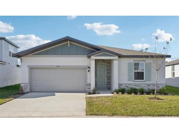 One-story home with gray siding, light green door, and landscaped lawn at 2149 Rosewood Dr, Bartow, FL 33830